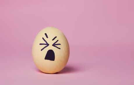 Illustration of an annoyed face drawn on an eggshell