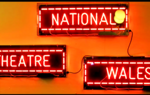Glowing signs that say National Theatre Wales