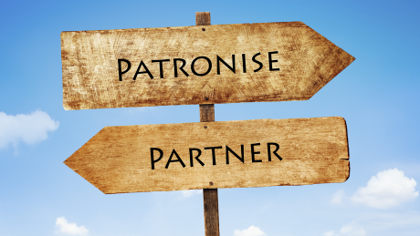 Signposts pointing to 'patronise' and 'partner'